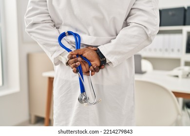 Young African American Man Wearing Doctor Uniform Holding Stethoscope At Clinic