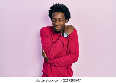 Young african american man wearing casual clothes hugging oneself happy and positive, smiling confident. self love and self care  - Shutterstock ID 2217283947