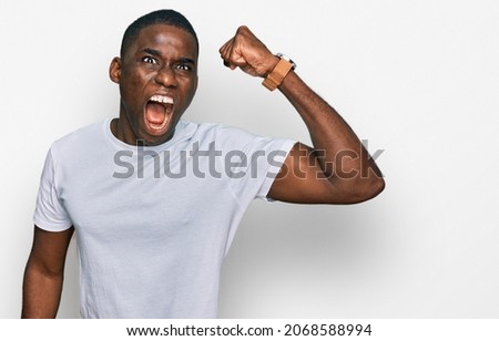 Similar – Cheerful man celebrating his success with a broad smile and raised fist in front of a neutral background