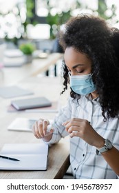 Young African American Manager In Medical Mask Holding Hand Sanitizer In Office