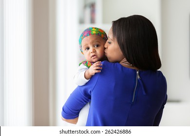 Young african american mother playing with her baby girl