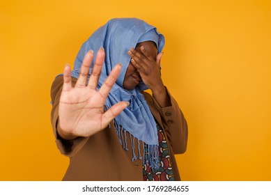 Young African American Muslim Woman Covers Eyes With Palm And Doing Stop Gesture, Tries To Hide From Everybody. Don't Look At Me, I Don't Want To See, Feels Ashamed Or Scared.