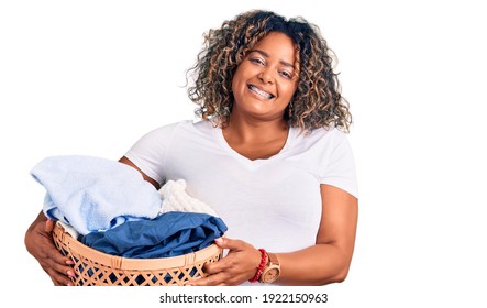 Young African American Plus Size Woman Holding Laundry Basket Looking Positive And Happy Standing And Smiling With A Confident Smile Showing Teeth 