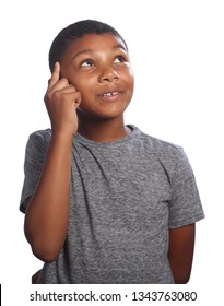Young African American school boy looking up, concentrating and thinking deeply, wearing grey t-shirt against white background