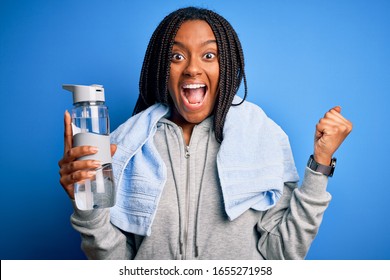 Young african american sports woman wearing sweatshirt and drinking water screaming proud and celebrating victory and success very excited, cheering emotion - Shutterstock ID 1655271958