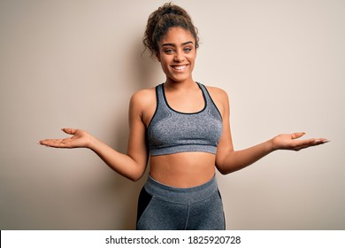 Young african american sportswoman doing sport wearing sportswear over white background smiling showing both hands open palms, presenting and advertising comparison and balance