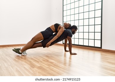 Young african american sporty couple doing push-ups exercise at sport center. - Powered by Shutterstock