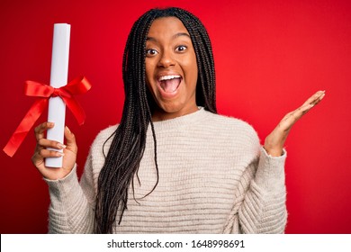 Young African American Student Girl Holding University Diploma Over Red Isolated Background Very Happy And Excited, Winner Expression Celebrating Victory Screaming With Big Smile And Raised Hands