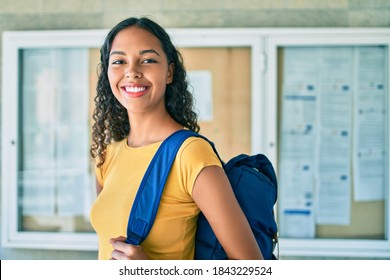 Young african american student girl smiling happy walking at university campus. - Shutterstock ID 1843229524