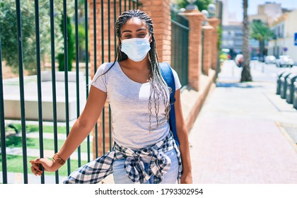 Young african american student woma wearing coronavirus safety mask at the university campus