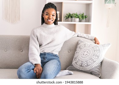 A Young African American Teen On A Sofa In Her Living Room Relaxing