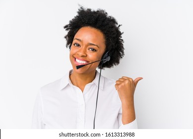 Young African American Telemarketer Woman Isolated Points With Thumb Finger Away, Laughing And Carefree.