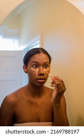 Young African American Woman Applying Concealer