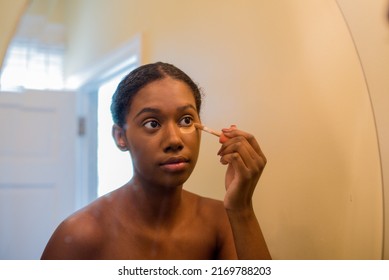 Young African American Woman Applying Concealer