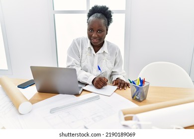 Young African American Woman Architect Using Laptop Writing On Notebook At Architecture Studio