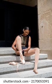 Young African American Woman Ballet Dancer Putting On Ballet Shoes Outside