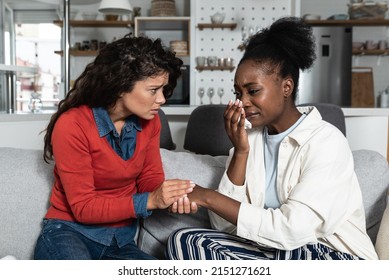 Young African American woman being victim of racism crying to her friend. Teenage female girl crime victim robed on the street.