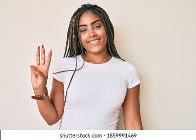 Young african american woman with braids wearing casual white tshirt showing and pointing up with fingers number three while smiling confident and happy. 