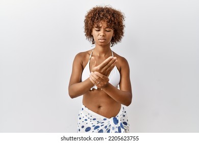 Young African American Woman With Curly Hair Wearing Bikini Suffering Pain On Hands And Fingers, Arthritis Inflammation 