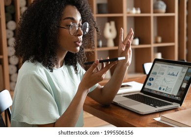 Young african american woman dictating voice message to client, chatting with friend, recording audio