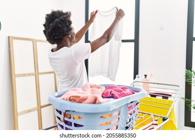 Young African American Woman Doing Laundry Looking Clothes At Laundry