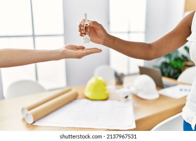 Young African American Woman Giving Key Of New Home At Architecture Studio