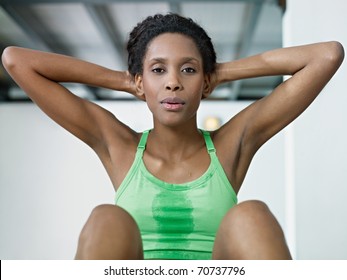 young african american woman in green sportswear exercising abdominals in fitness club, looking at camera. Horizontal shape, front view, waist up - Powered by Shutterstock