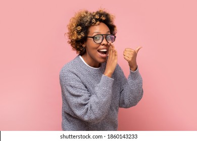 Young African American Woman With Hand On Mouth Telling Secret Or Rumor, Whispering. Studio Shot On Pink Wall.