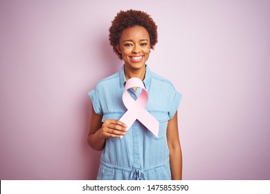 Young African American Woman Holding Brest Cancer Ribbon Over Isolated Pink Background With A Happy Face Standing And Smiling With A Confident Smile Showing Teeth