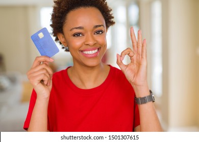 Young African American Woman Holding Credit Card Doing Ok Sign With Fingers, Excellent Symbol