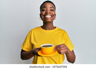 Young african american woman holding coffee smiling with a happy and cool smile on face. showing teeth. 