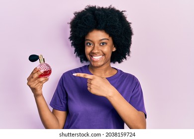 Young African American Woman Holding Perfume Smiling Happy Pointing With Hand And Finger 