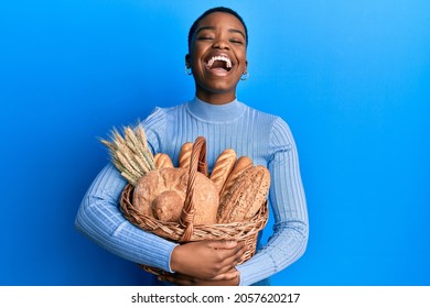 Young african american woman holding wicker basket with bread smiling and laughing hard out loud because funny crazy joke.  - Powered by Shutterstock