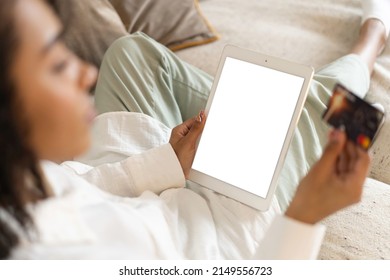 Young African American Woman Holding Credit Card And Using Tablet At Home. Online Shopping, E-commerce, Internet Banking.