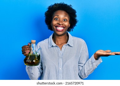 Young African American Woman Holding Olive Oil Can Celebrating Achievement With Happy Smile And Winner Expression With Raised Hand 