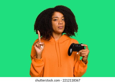 Young African American Woman Holding A Game Controller Isolated Showing Number One With Finger.