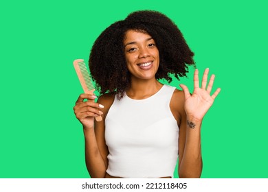 Young African American Woman Holding Hair Comb Isolated Smiling Cheerful Showing Number Five With Fingers.