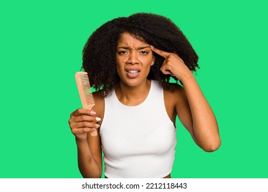 Young African American Woman Holding Hair Comb Isolated Showing A Disappointment Gesture With Forefinger.