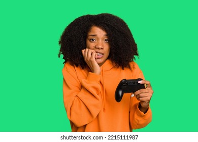 Young African American woman holding a game controller isolated biting fingernails, nervous and very anxious. - Powered by Shutterstock