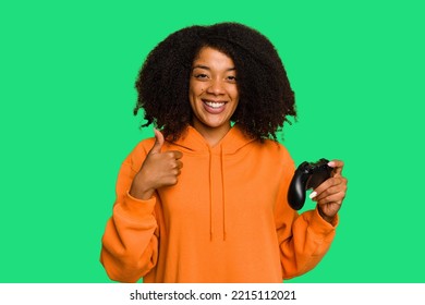 Young African American Woman Holding A Game Controller Isolated Smiling And Raising Thumb Up