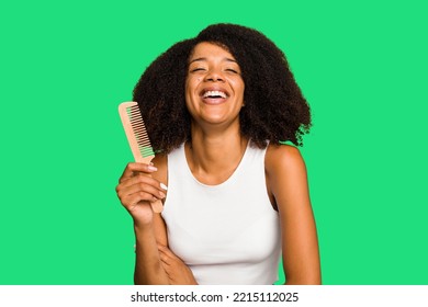 Young African American Woman Holding Hair Comb Isolated Laughing And Having Fun.