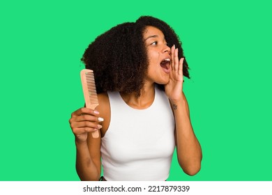 Young African American Woman Holding Hair Comb Isolated Shouting And Holding Palm Near Opened Mouth.