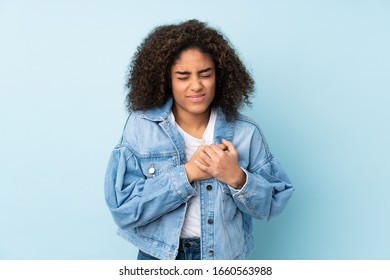 Young African American Woman Isolated On Blue Background Having A Pain In The Heart