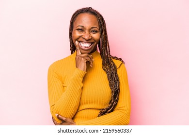 Young african american woman isolated on pink background smiling happy and confident, touching chin with hand.
