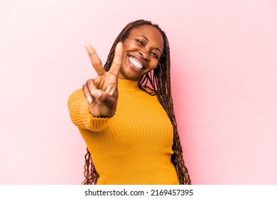 Young African American Woman Isolated On Pink Background Joyful And Carefree Showing A Peace Symbol With Fingers.