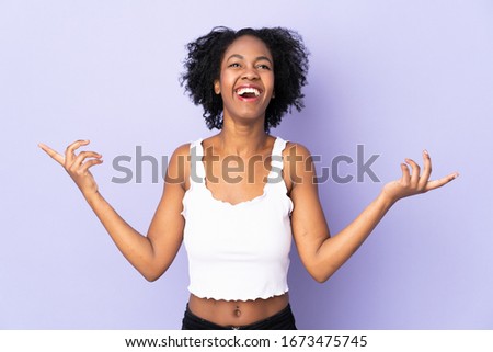 Young African American woman isolated on purple background smiling a lot