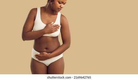 Young African American Woman On Yellow Studio Background In Underwear Feel Unhealthy Suffer From Heartache. Pain In Chest Concept. Unwell Black Female Struggle With Heart Attack Or Ache.