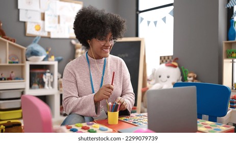 Young african american woman on a video call working as teacher at kindergarten - Shutterstock ID 2299079739