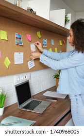 Young African American Woman Pin Weekly Planning Sticker On Mood Board At Home Office. Black Girl Put Post It Sticky Note Memo On Board To Organize Work Goals, Self Organization Concept. Vertical