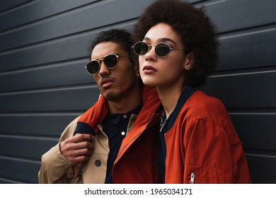 young african american woman posing with stylish man in sunglasses outside - Powered by Shutterstock